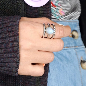 Gros plan sur une bague triple en argent rétro avec perles et pierre de lune ovale