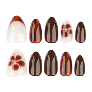 Red amber and white press-on nails with floral patterns and almond shape on white backdrop