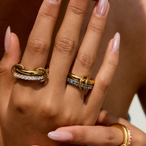 Close-up of gold titanium link ring with colorful zircon stones on model's hand