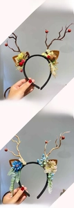 Vue détaillée de serre-têtes bois de renne avec pommes de pin et fleurs artificielles