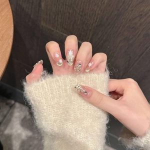 Detailed view of winter snowflake press-on nails with white snowflakes and pearl accents