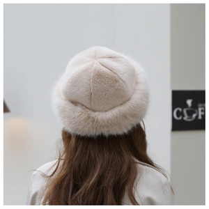Detail view of the thick faux fur texture on a cream-white winter beret from behind
