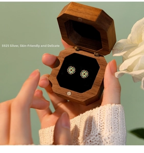 Detail of s925 silver flower stud earrings with emerald zircon in a premium wood gift box