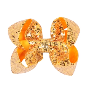 Detail view of a 5-inch orange yellow sequin hair bow with shiny metallic finish