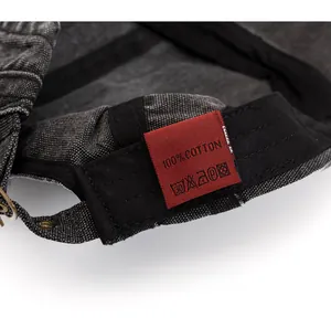 Detail of internal care label and red 100% cotton tag on washed canvas newsboy cap