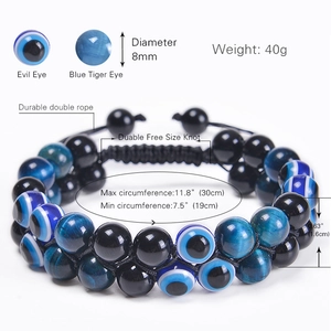 Bracciale Evil Eye a doppio strato con occhio di tigre blu e perle nere su sfondo bianco