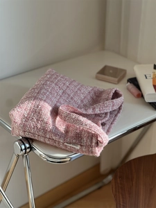 Texture détaillée du tissu en tweed rose et blanc sur la surface d'un sac cabas tissé