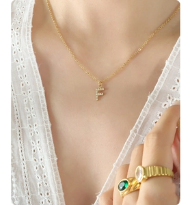 Close-up of letter F pendant necklace in gold finish with sparkling zircon inlay
