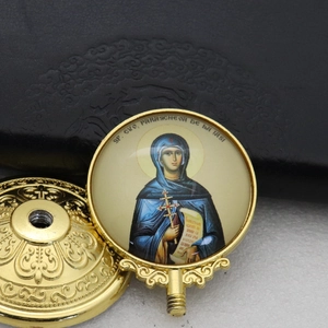 Detail of gold-plated Saint Parascheva religious medal and threaded decorative cap