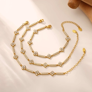 Detailed view of three gold-plated stainless steel clover bracelets with zircon inlay