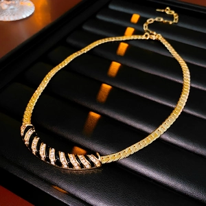 Dettaglio della collana vintage placcata oro con spirali smaltate nere e micro-cristalli