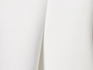 Vista macro del tessuto bianco elastico per top a gonna e pantaloni a zampa da donna
