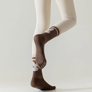 Close-up of non-slip silicone grips and cute rabbit design on brown five-finger yoga socks