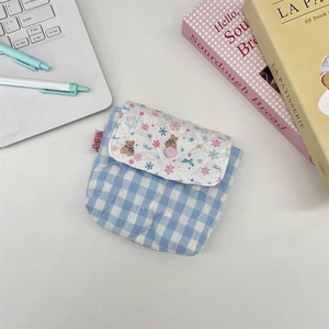 Detailed macro view of a quilted blue plaid mini pouch with a cute bear printed on it