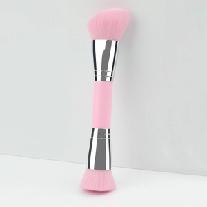 Dual-ended pink makeup brush with angled and flat foundation bristles on white background