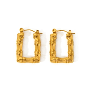 Vue détaillée des boucles d'oreilles dorées en U avec finition texture bambou sculptée