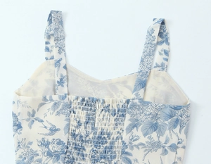 Detail view of the floral bird print sundress featuring back smocking and hidden zipper