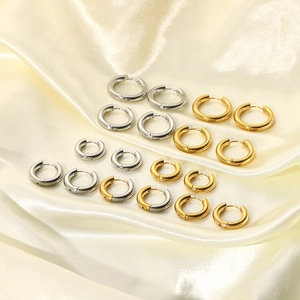 Polished titanium steel hoop earring set in gold and silver on silk background