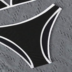 Close-up of black bikini bottom with white contrast binding and stitching details