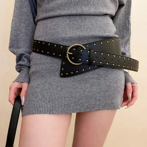 Detail of vintage punk wide black leather belt with triple-row brass studs and large round buckle