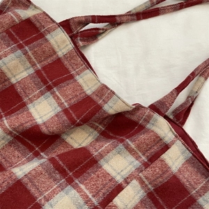 Gros plan sur le tissu à carreaux rouge, blanc et gris d'un sac cabas au style rétro