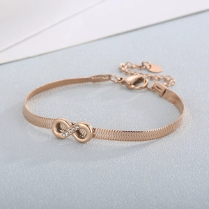 Macro detail of rose gold infinity bracelet with crystals and snake chain texture