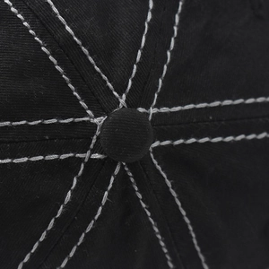 Detail of black cotton baseball cap top button with contrasting white stitching