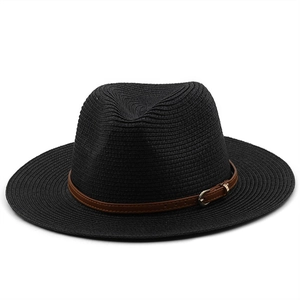 Detail of black woven fedora straw hat featuring a brown leather band and gold buckle
