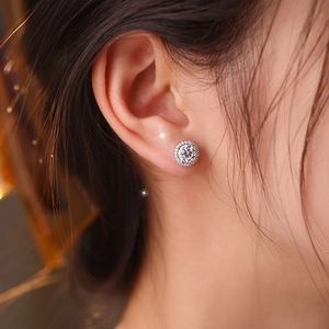 Elegant 925 sterling silver moissanite stud earrings shown on a female model's ear lobe
