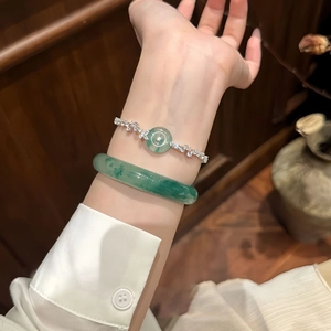 Dettaglio del bracciale di giada verde smeraldo e braccialetto di zirconi al polso