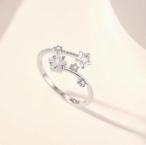 Silver adjustable S925 star ring with cubic zirconia inlay on beige background