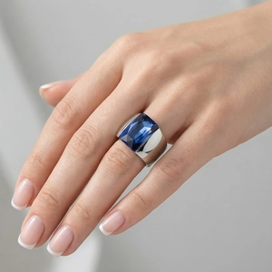 Macro view of a square-cut deep blue stone set in a wide silver-tone titanium ring