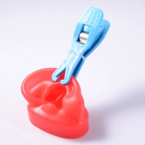 Blue acrylic ear piercing tool with red silicone ear model for professional piercing practice