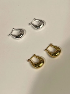 Flat lay detail of minimalist 925 sterling silver tulip U-shaped hoop earrings in gold and silver