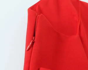 Close-up of the red dress showing detailed concealed side zipper and twill fabric texture