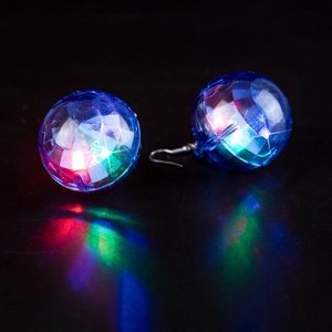 Macro shot of blue glowing disco ball earrings with colorful LED lights on black surface