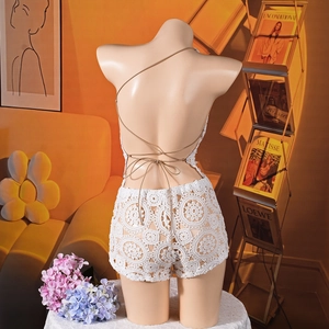 Dettaglio di un completo in pizzo bianco all'uncinetto con design schiena scoperta e lacci