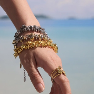 Golden heart pendant bracelet with thorn link design and matching green gemstone ring