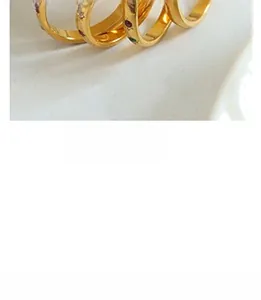 Detail of vintage gold plated rings set with colorful gemstones on white background