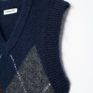 Vintage Strickweste mit V-Ausschnitt, marineblauem Rautenmuster und weicher Textur