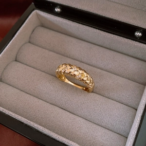 Macro shot of gold-plated twisted ring with sparkling zircons in a jewelry box