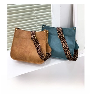 Detail view of square tote bags with leopard print wide straps and golden metal hardware