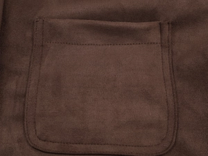 Detailed close-up of stitching on a dark brown suede pocket with a textured finish