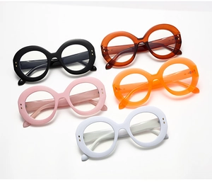 Overhead view of oversized round glasses in five vibrant colors including black and orange