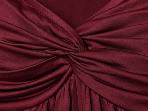 Makroaufnahme des weinroten Strickoberteils mit eckigem Ausschnitt und Knotendesign