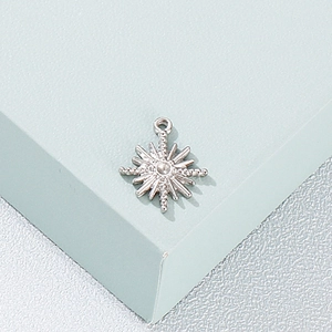 Pendentif étoile en acier inoxydable argenté sur un support texturé vert clair