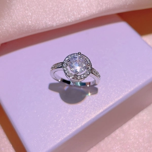 Elegant silver halo ring featuring a large round cubic zirconia on a luxury silk background