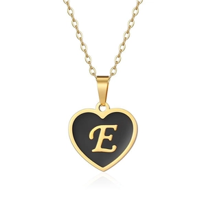 Detail shot of heart-shaped gold pendant with black enamel inlay and letter E engraving