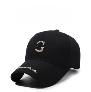 Détail de la broderie dorée de la lettre aG sur une casquette de baseball noire