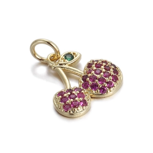 Close-up of 14k gold cherry pendant with red gemstones and a green crystal leaf